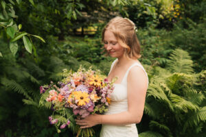 a bride in a grace loves lace wedding dress with wildflower bouquet 