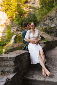 newlyweds embracing each other at the base of a waterfall at Robert H. Treman State Park in upstate new york