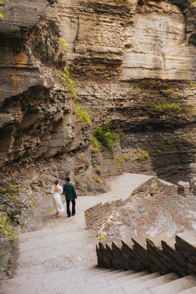 newlyweds walking together at Robert H. Treman State Park in upstate new york