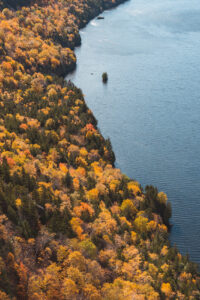 a colorful autumn scene of the trees of the Adirondack Mountains and fresh lake water