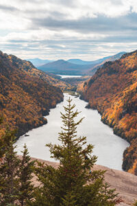 a colorful autumn scene of the trees of the Adirondack Mountains and fresh lake water