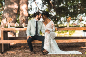 a bride and groom sit next to each other at their microwedding reception at gatherwild ranch