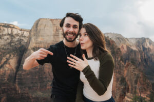 a woman and a man pointing at their new engagement rings