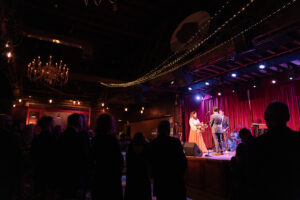 a bride and groom stand on stage for their ceremony