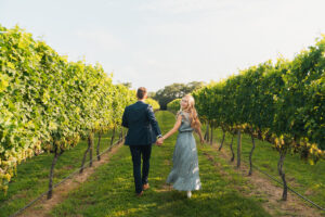 a newly engaged couple running through a winery