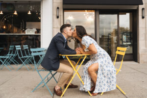 a couple kisses over a colorful table in a popular town