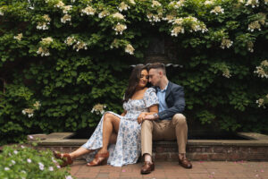 a man and woman sit among a lush garden