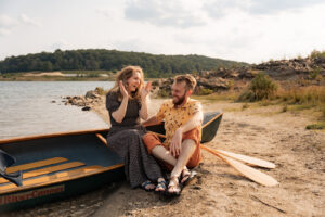 a woman and man sit in a canoe laughing 