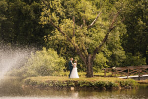 newlyweds dance under a tree on a lake island