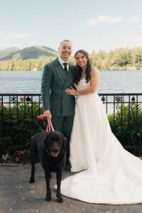 a bride and groom standing with their dog