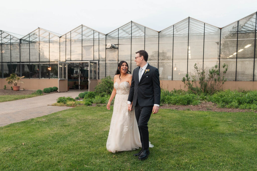 bride and groom walking the green grounds in The Conservatory wedding venue in New Jersey