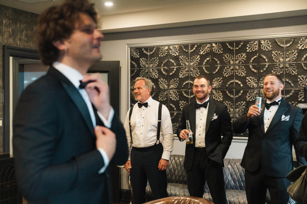 groomsmen helping the groom get ready