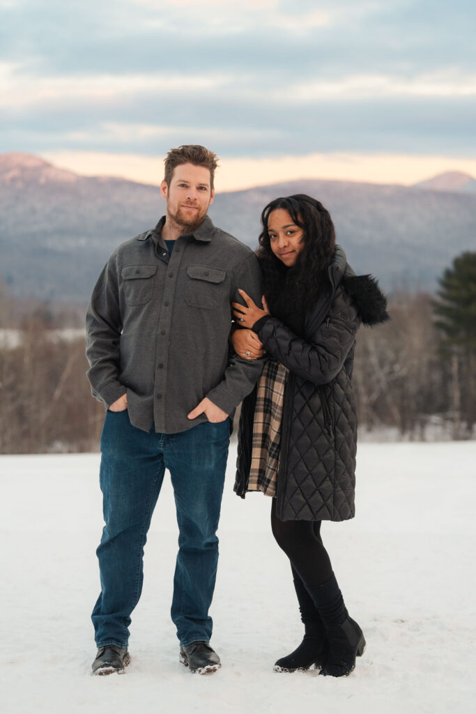 a couple during a winter sunset and mountains in the background