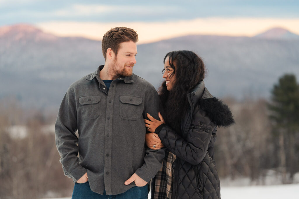 a couple during a winter sunset and mountains in the background