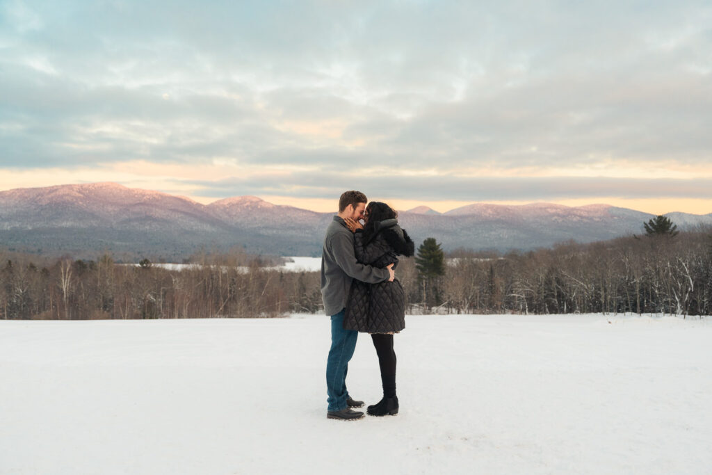 a couple during a winter sunset and mountains in the background