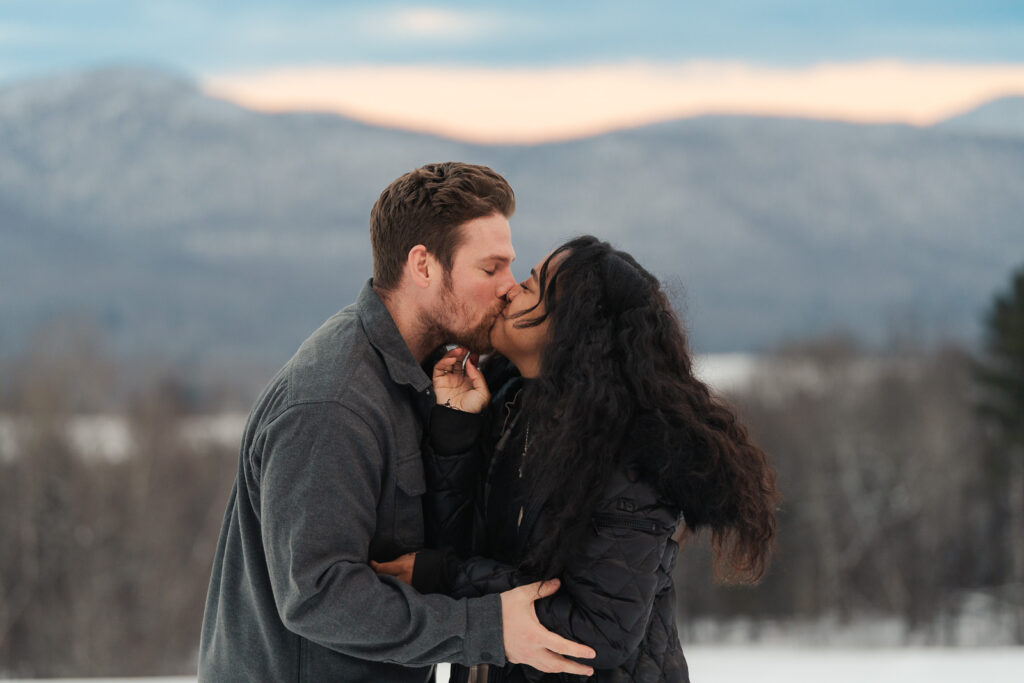 a couple during a winter sunset and mountains in the background