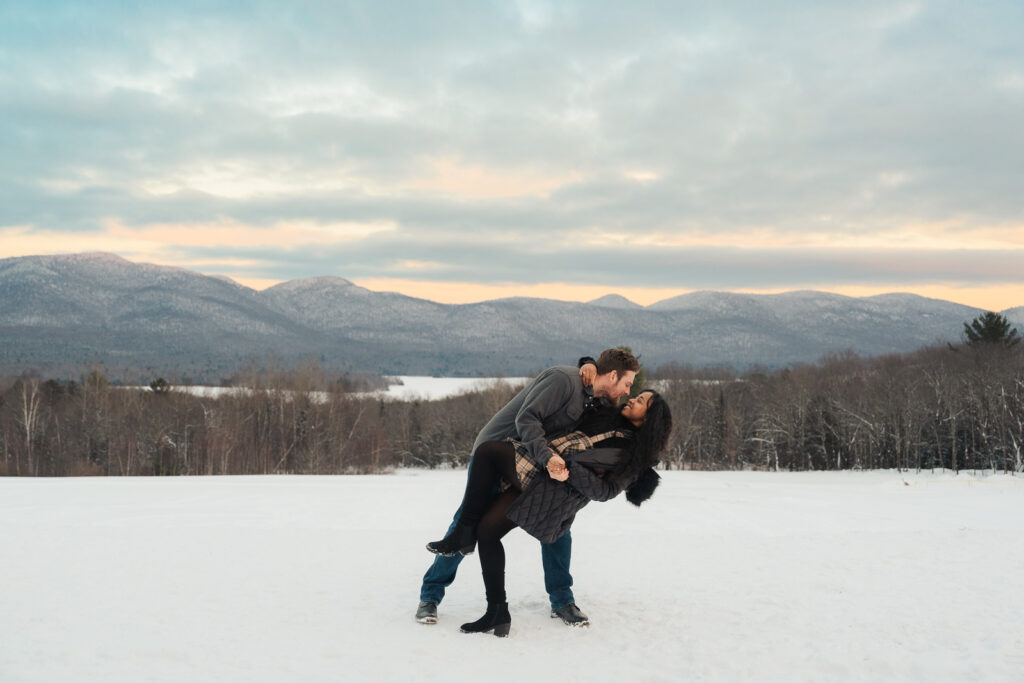 a couple during a winter sunset and mountains in the background