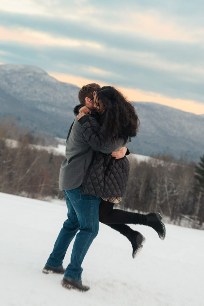 a couple during a winter sunset and mountains in the background