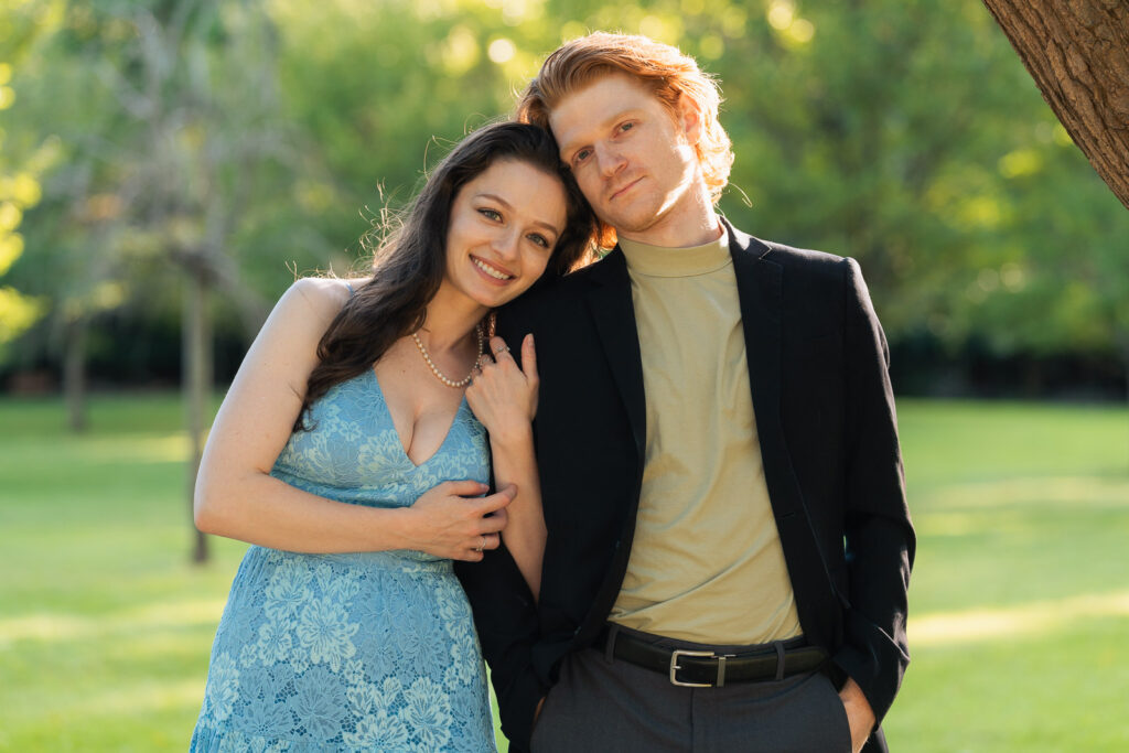 a couple taking anniversary photos in a park during summer