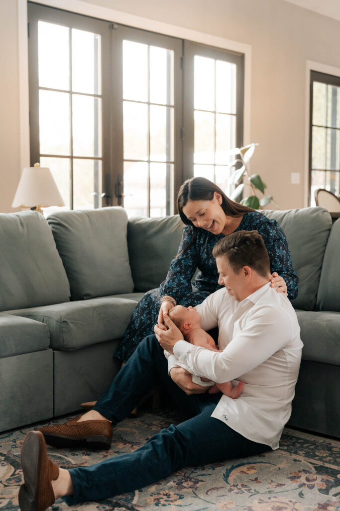 A mom and father hold their newborn for an intimate newborn photography session.