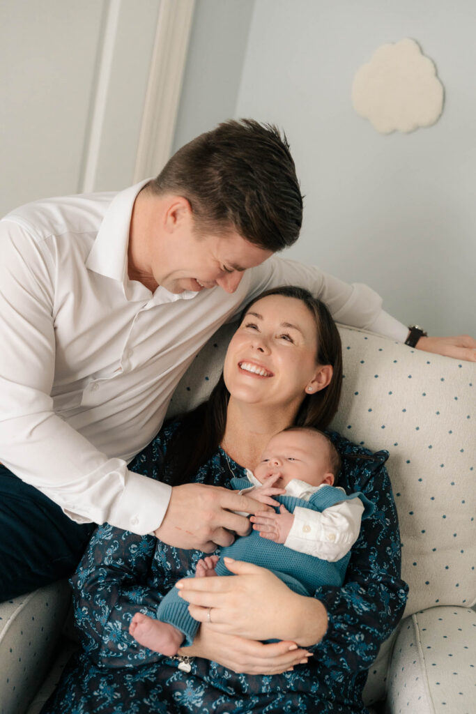 A mom and father hold their newborn for an intimate newborn photography session.
