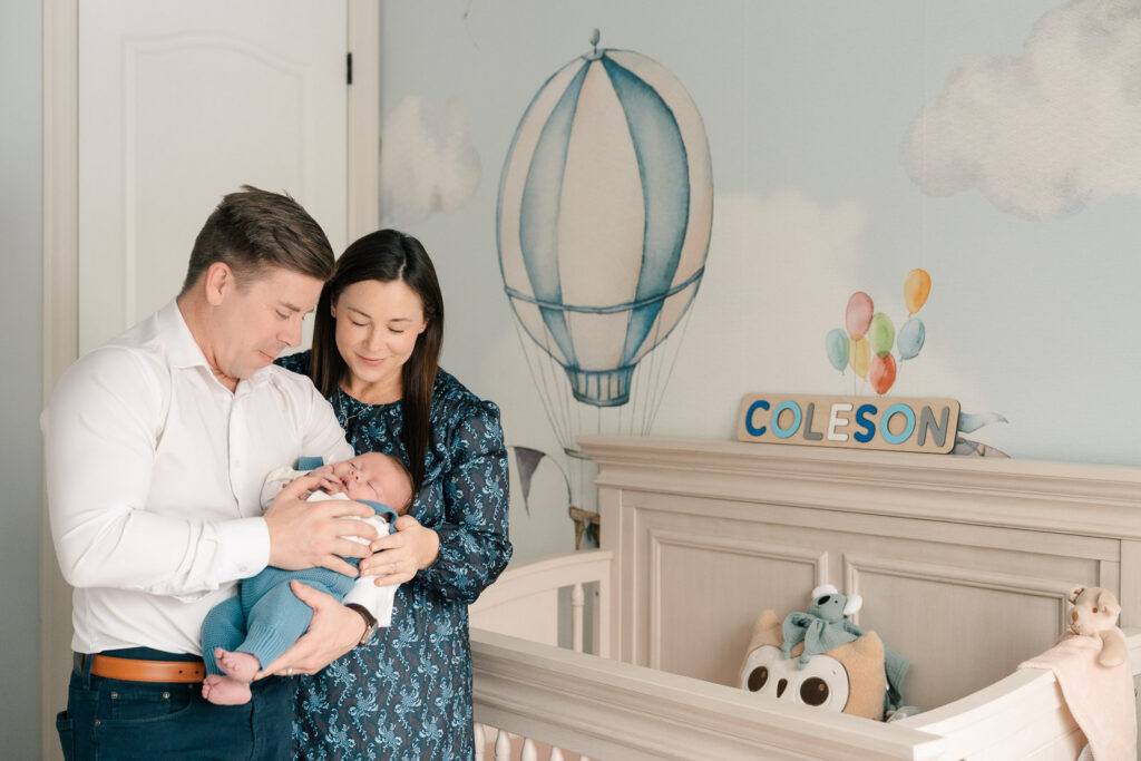 A mom and father hold their newborn for an intimate newborn photography session.