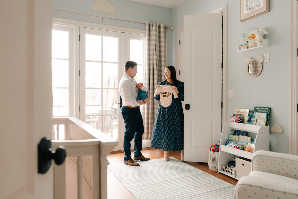 A mom and father hold their newborn for an intimate newborn photography session.