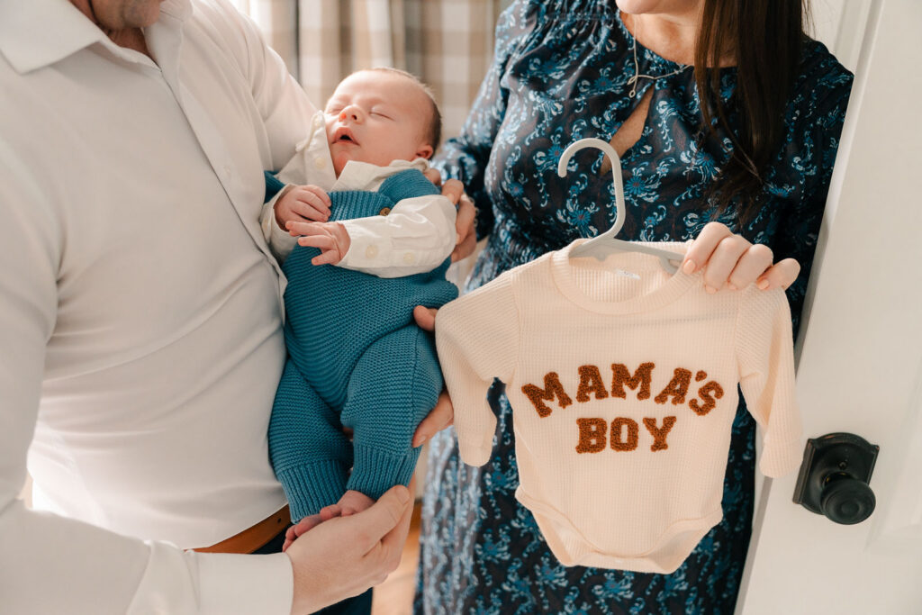 A mom and father hold their newborn for an intimate newborn photography session.