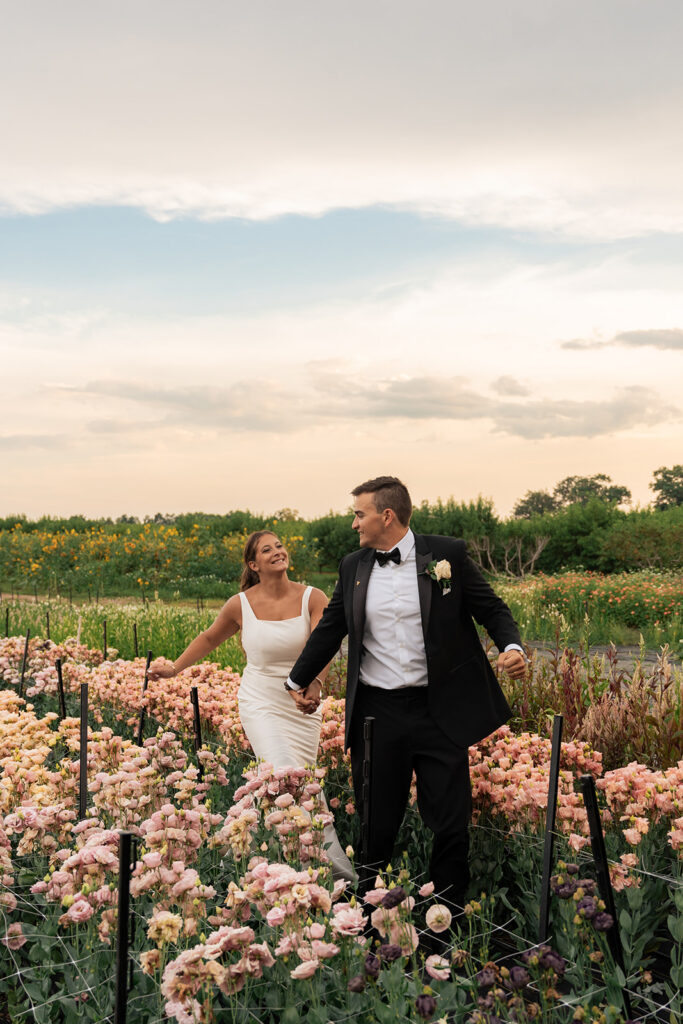 Newlyweds running through a flower field.