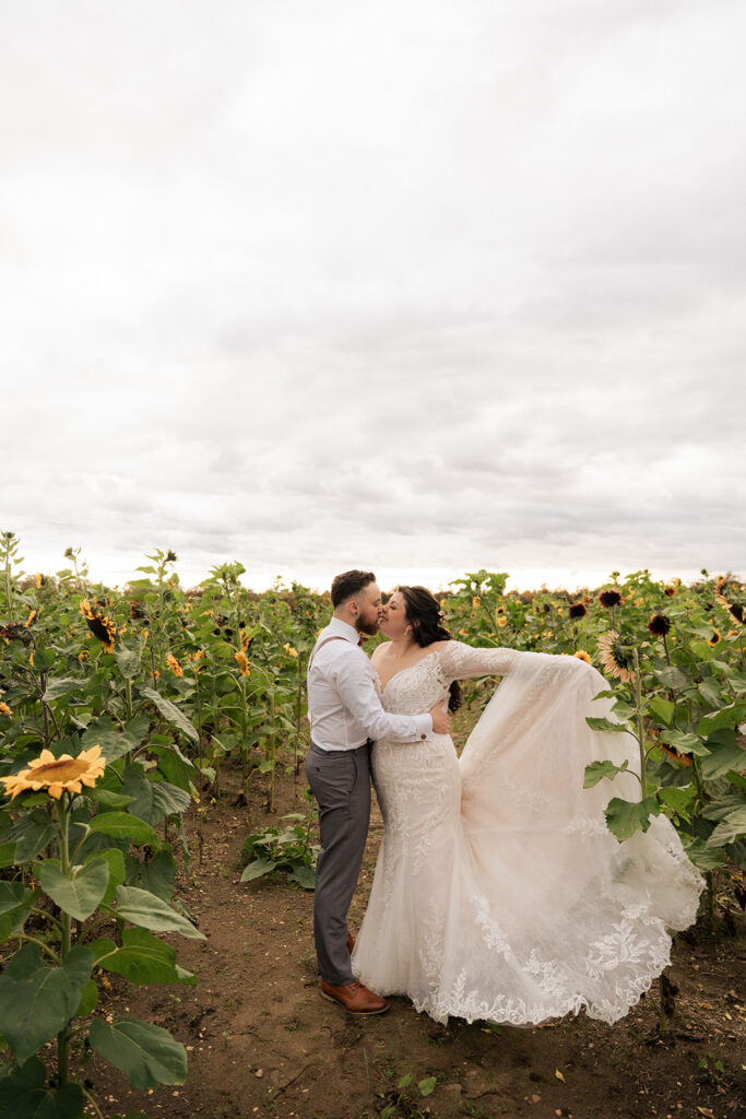 A bride and groom in a sunflower field.