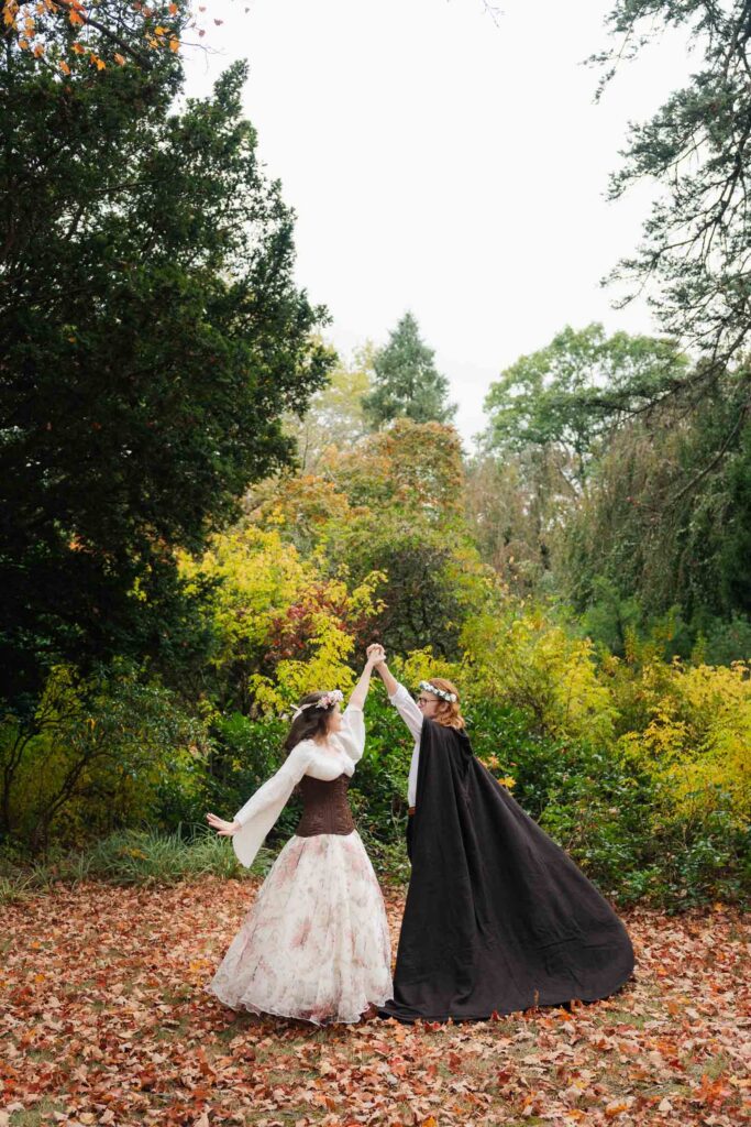 A Renaissance-inspired autumn engagement session at Skylands Manor and the New Jersey Botanical Gardens in Ringwood, NJ, featuring flower crowns, a wool cape, and romantic garden portraits before a Stone House wedding.
