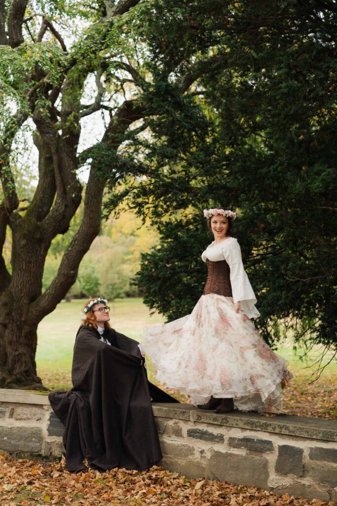 A Renaissance-inspired autumn engagement session at Skylands Manor and the New Jersey Botanical Gardens in Ringwood, NJ, featuring flower crowns, a wool cape, and romantic garden portraits before a Stone House wedding.