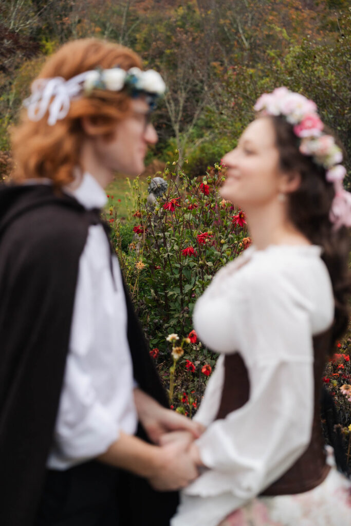 A Renaissance-inspired autumn engagement session at Skylands Manor and the New Jersey Botanical Gardens in Ringwood, NJ, featuring flower crowns, a wool cape, and romantic garden portraits before a Stone House wedding.