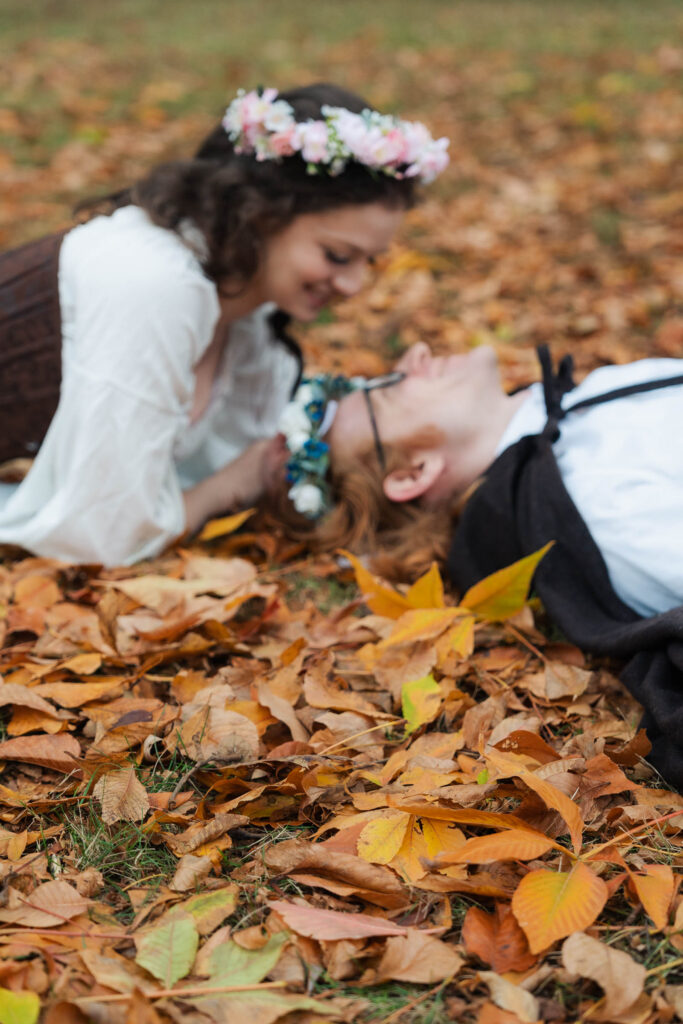 A Renaissance-inspired autumn engagement session at Skylands Manor and the New Jersey Botanical Gardens in Ringwood, NJ, featuring flower crowns, a wool cape, and romantic garden portraits before a Stone House wedding.