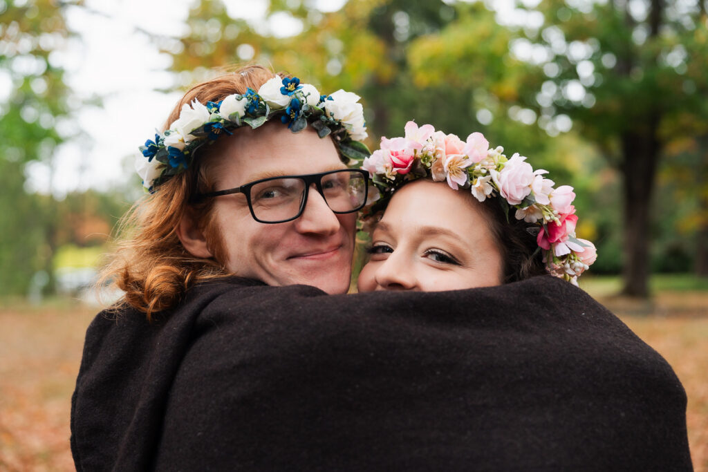 A Renaissance-inspired autumn engagement session at Skylands Manor and the New Jersey Botanical Gardens in Ringwood, NJ, featuring flower crowns, a wool cape, and romantic garden portraits before a Stone House wedding.