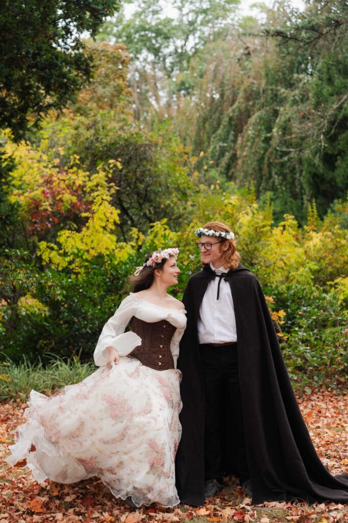 A Renaissance-inspired autumn engagement session at Skylands Manor and the New Jersey Botanical Gardens in Ringwood, NJ, featuring flower crowns, a wool cape, and romantic garden portraits before a Stone House wedding.