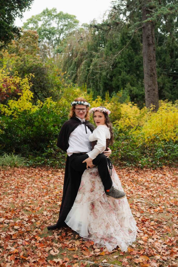 A Renaissance-inspired autumn engagement session at Skylands Manor and the New Jersey Botanical Gardens in Ringwood, NJ, featuring flower crowns, a wool cape, and romantic garden portraits before a Stone House wedding.