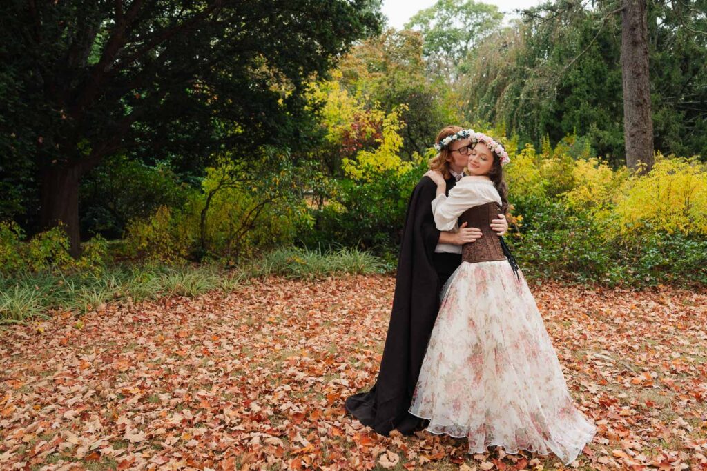 A Renaissance-inspired autumn engagement session at Skylands Manor and the New Jersey Botanical Gardens in Ringwood, NJ, featuring flower crowns, a wool cape, and romantic garden portraits before a Stone House wedding.