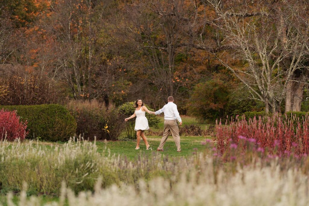 A vintage-inspired late autumn engagement session at Skylands Manor and the New Jersey Botanical Gardens in Ringwood, NJ, featuring fall foliage, classic outfits, and romantic garden portraits.